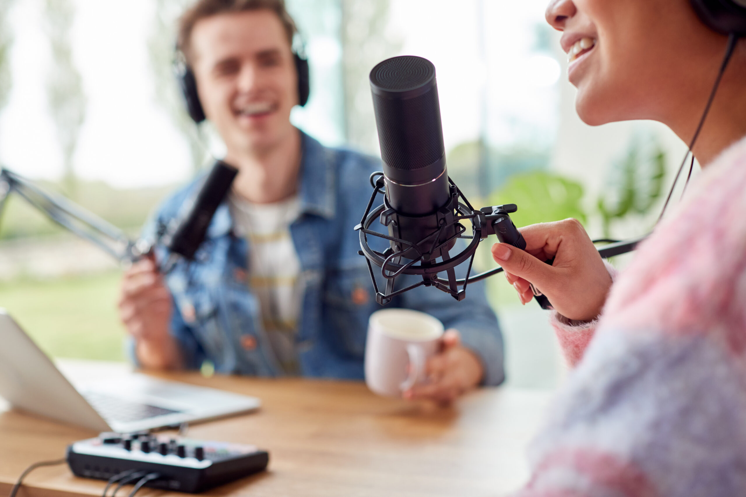 Close Up Of Couple Recording Podcast Or Broadcasting Interview On Radio In Studio At Home