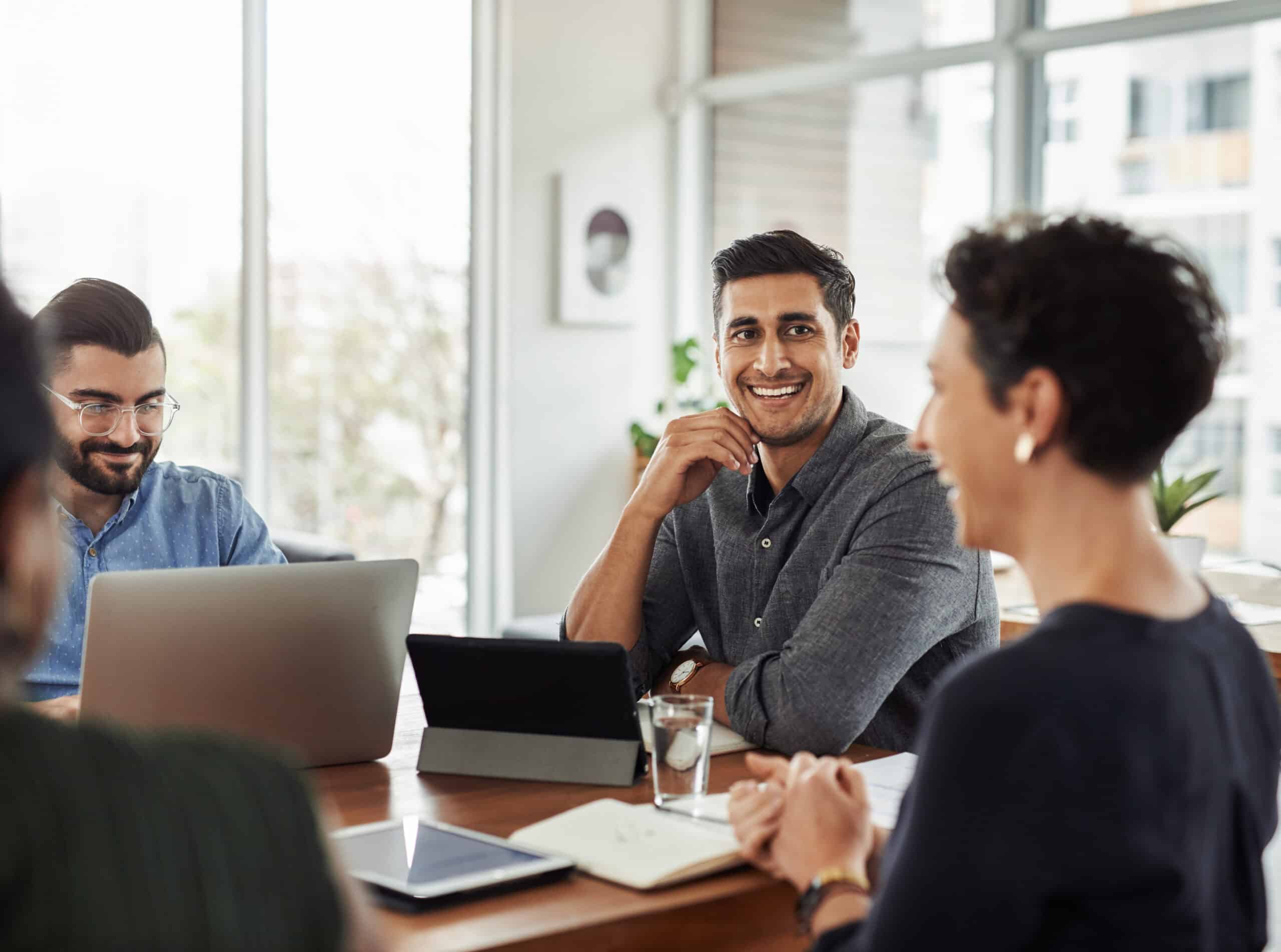 Shot of a handsome young businessman smiling during a meeting with colleagues at w